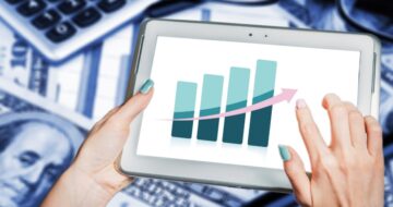 a person holding a tablet with a graph that represents business trends