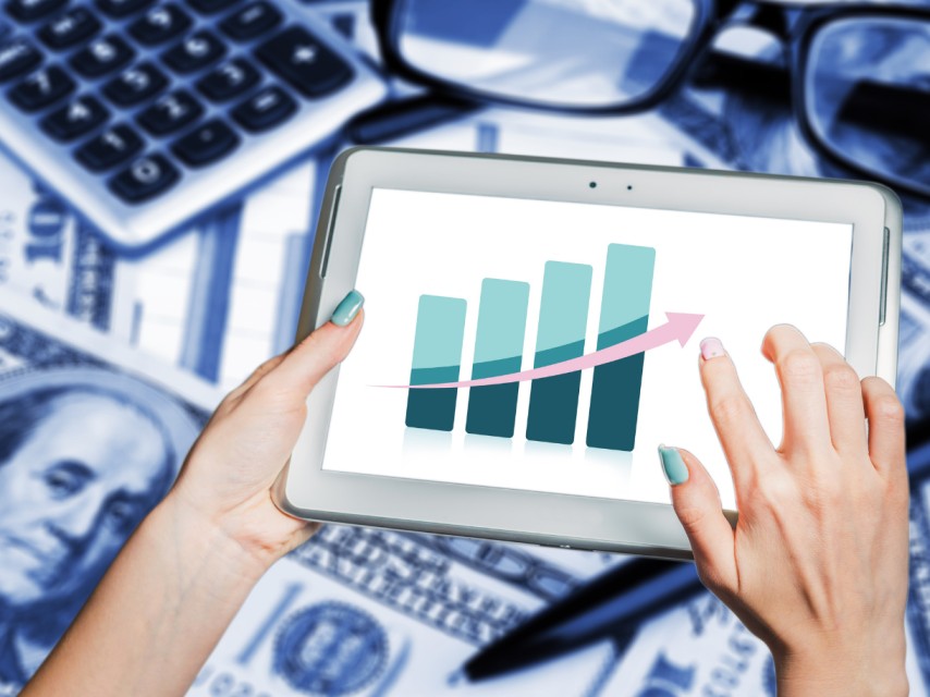 a person holding a tablet with a graph that represents business trends