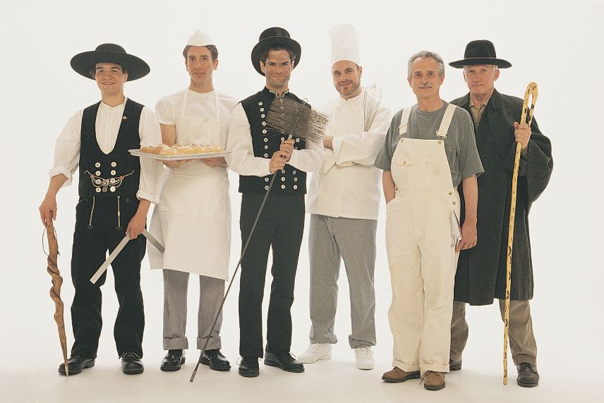 a group of men wearing different uniforms, indicating they work in blue-collar jobs