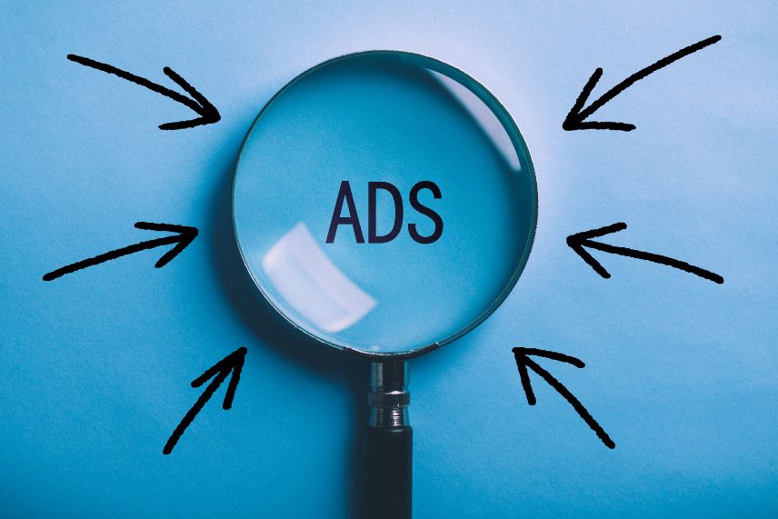 a magnifying glass with arrows pointing to the word ads