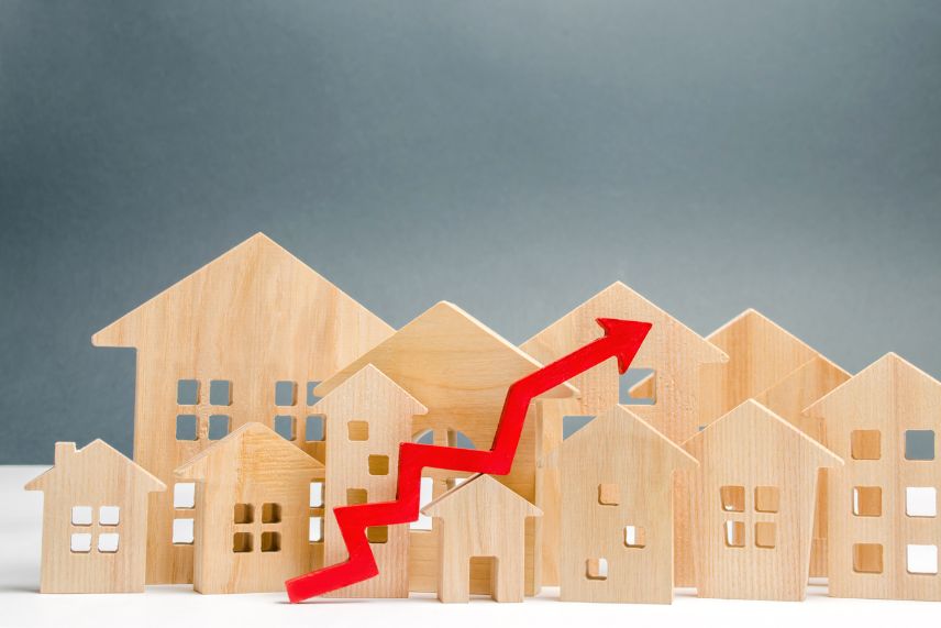 a red arrow going up in front of wooden houses representing tiered pricing